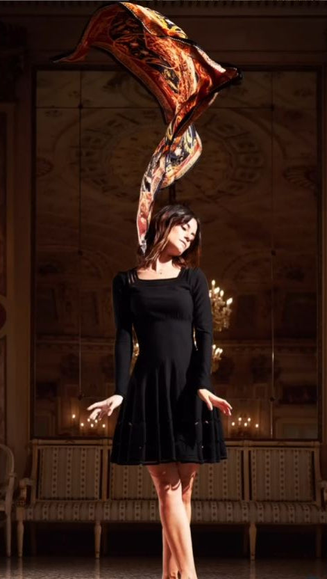 woman with black dress and a colourful silk scarf flying above her