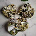 silk scrunchie with green, white and gold patterns