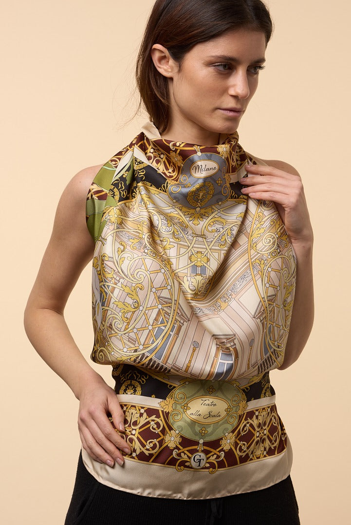 brunette woman wearing silk scarf as a dress. The scarf depicts theatre La Scala of Milan