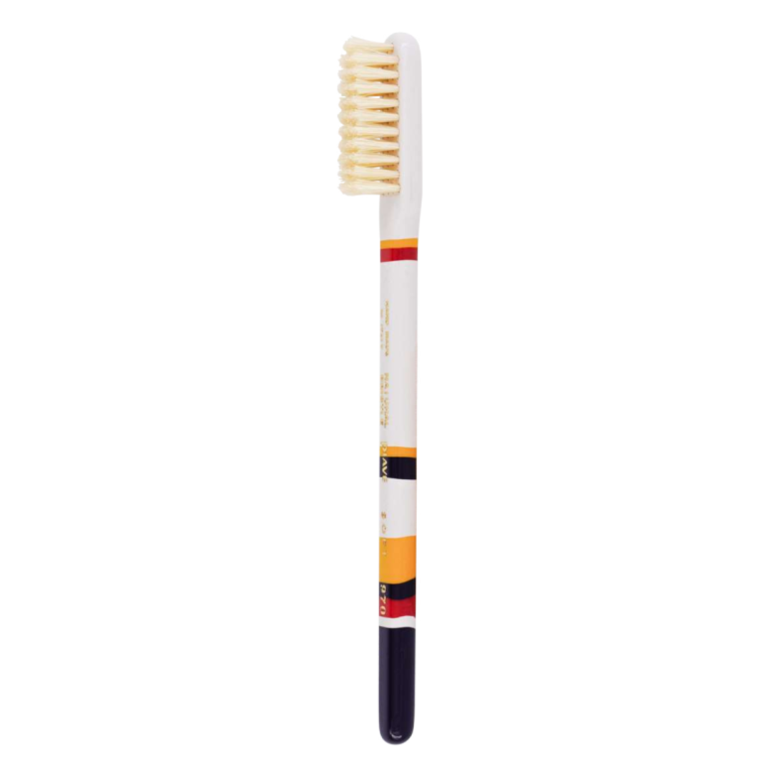 A single dental toothbrush with a white handle, cream-colored bristles, and colored bands in red, yellow, and black near the neck, set against a plain white background.