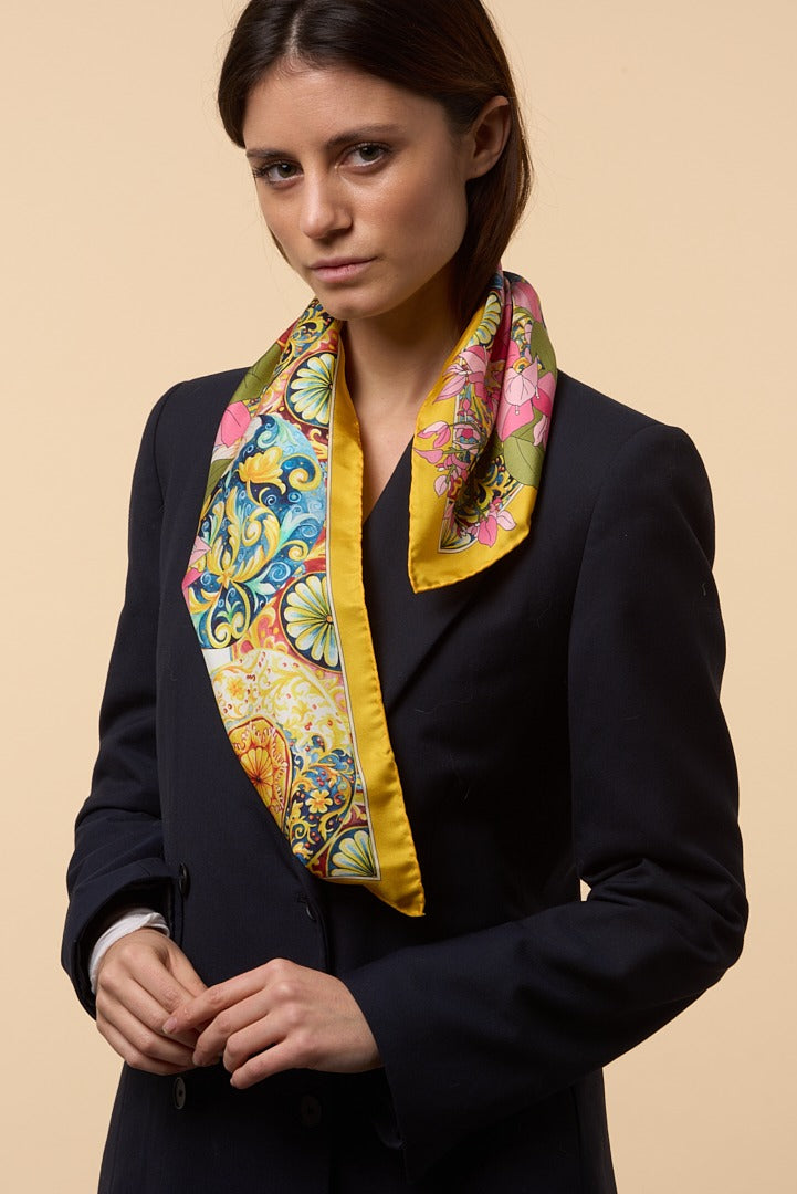 brunette woman wearing a blue coat and a colourful silk scarf