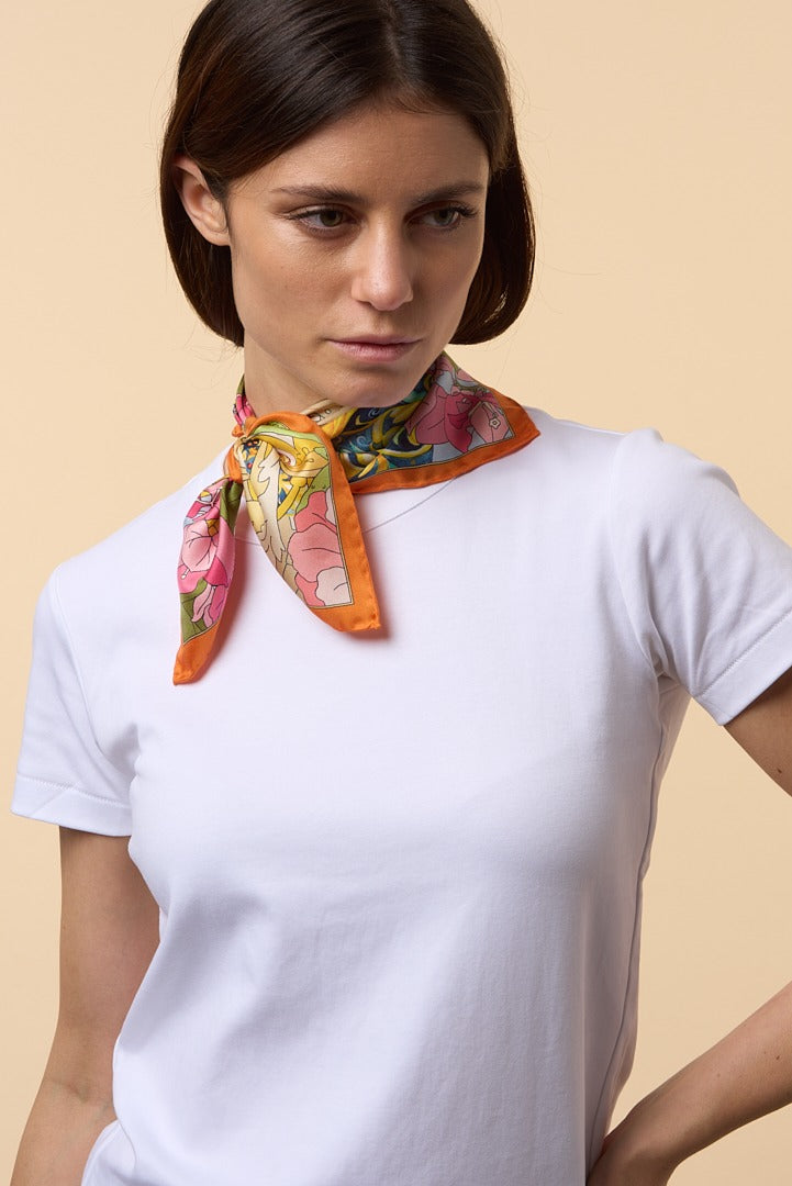 brunette woman with white t-shirt and orange silk scarf on her neck