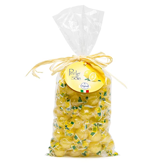 A clear plastic bag filled with yellow lemon-shaped candies, tied with a beige ribbon and topped with a round yellow label that reads 'Perle di Sole'.