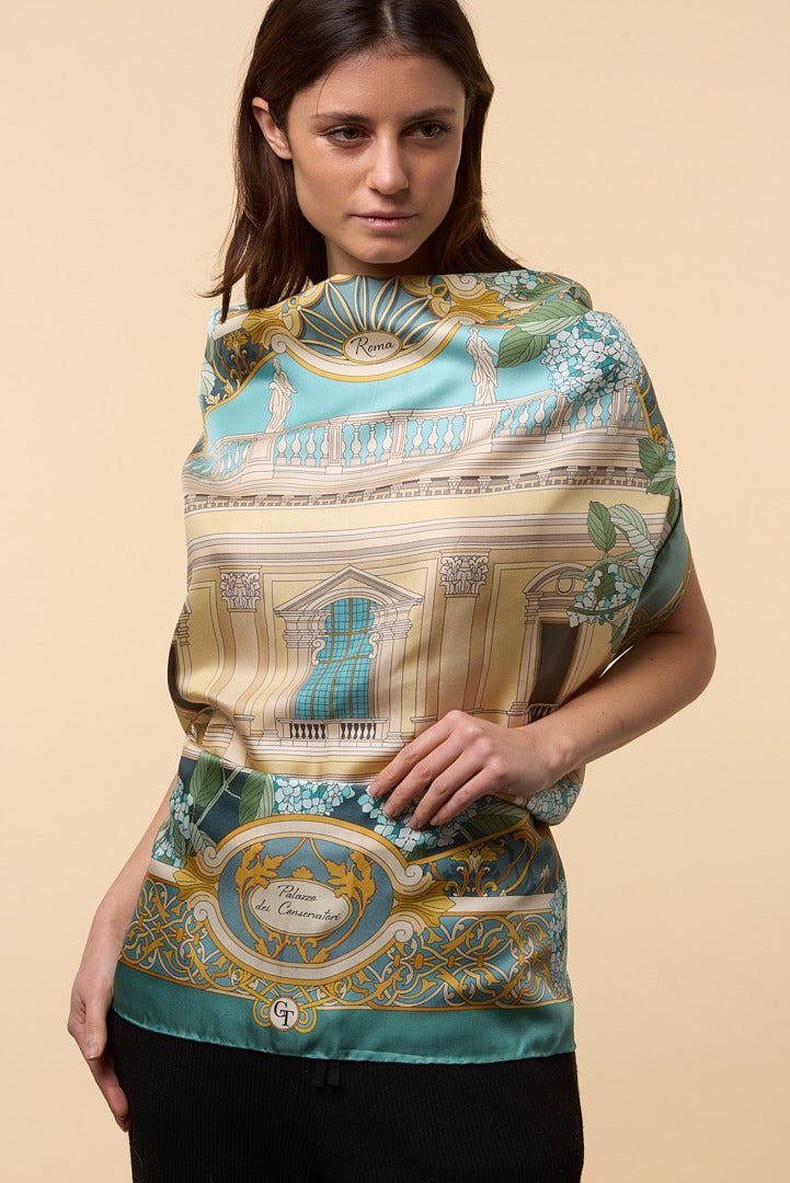 brunette woman wearing blue, white and gold silk scarf depicting a Roman palace as a dress