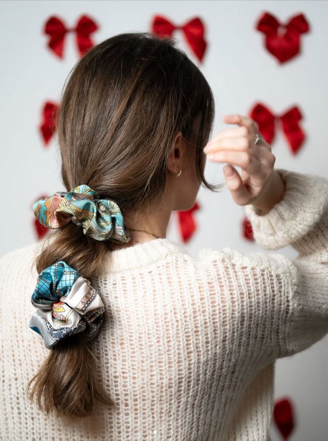 brunette girl viewed from the back, with two silk scrunchies on her hair