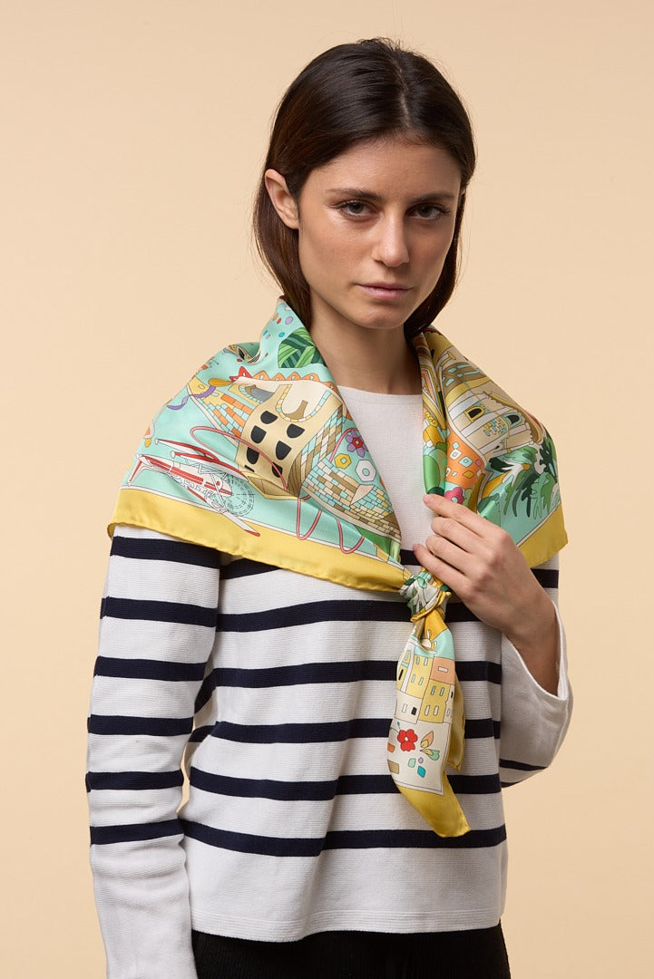 brunette woman wearing a striped shirt and a colourful silk scarf