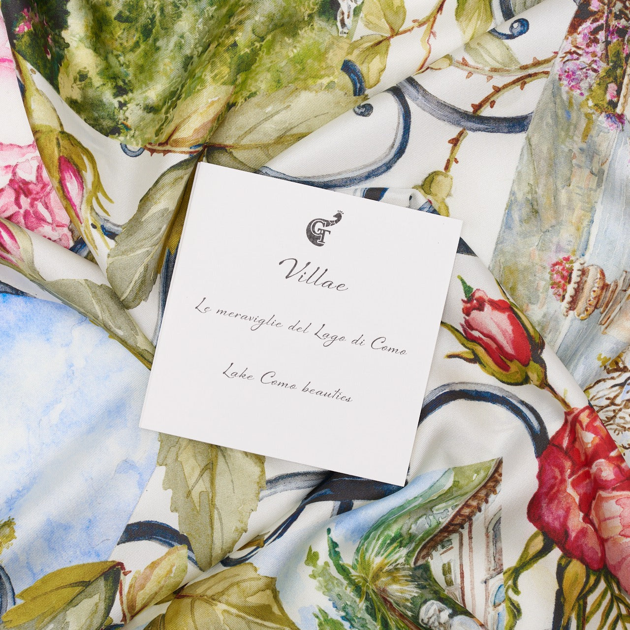 white note about lake Como on top of a colourful silk scarf depicting flowers