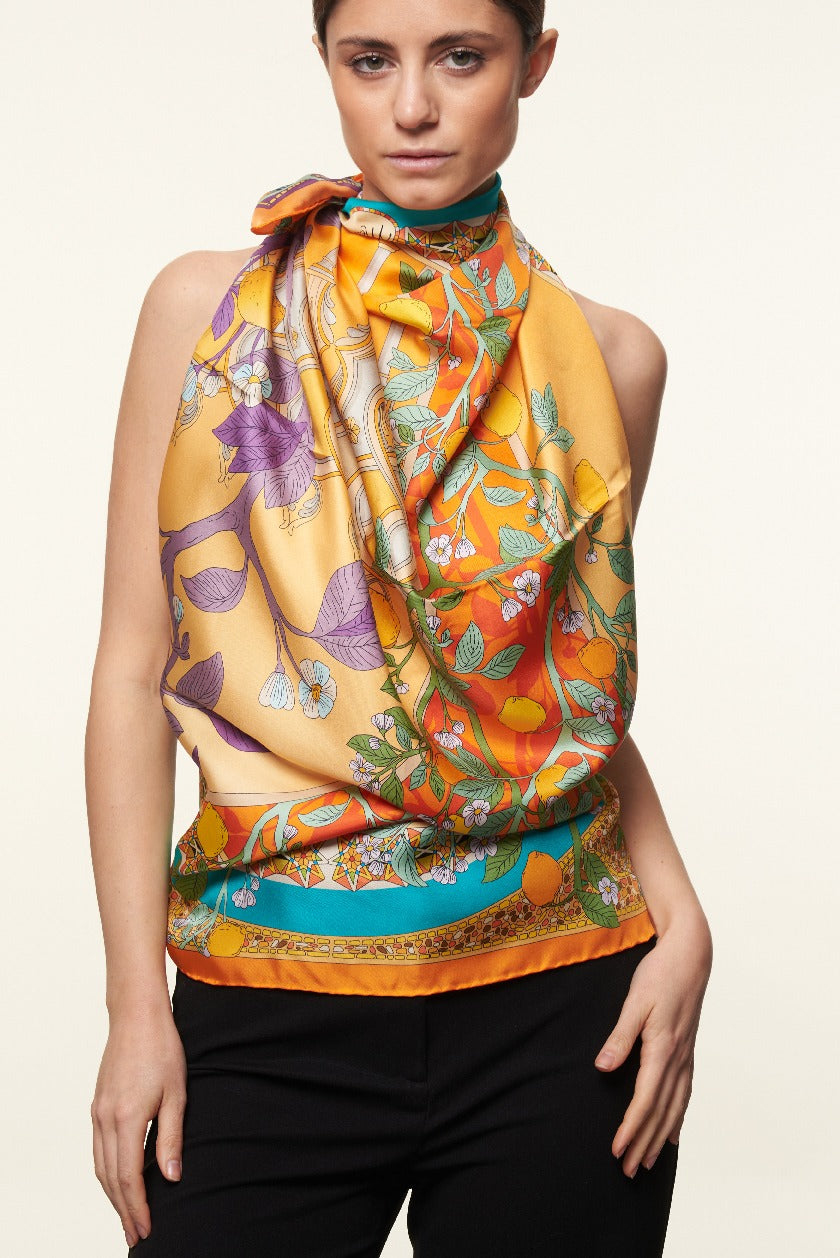 woman wearing yellow and orange silk scarf with lemons design as a dress