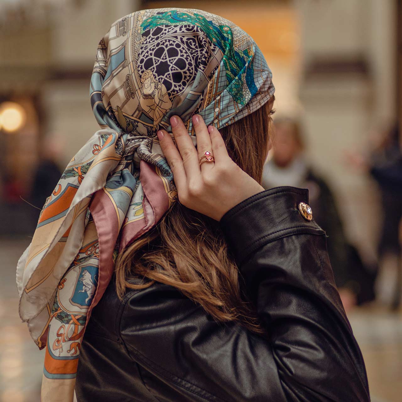 woman wearing a black leather jacket and asilk scarf on her head