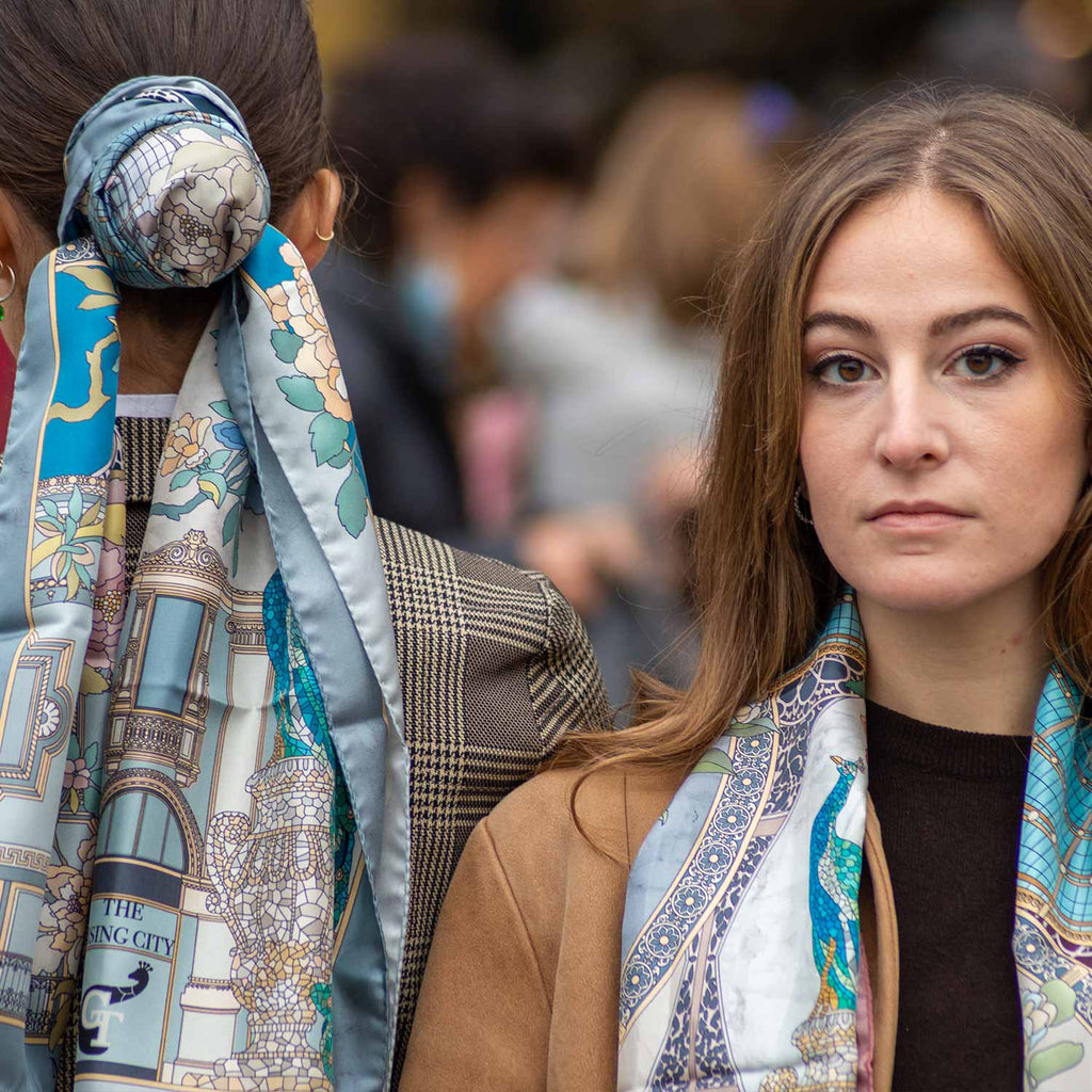 two women wearing silk scarves on their neck and hair