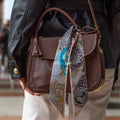 silk twilly on a brown leather bag