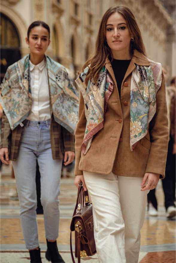two women walking inside galleria Vittorio Emanuele wearing elegant clothes and silk scarves