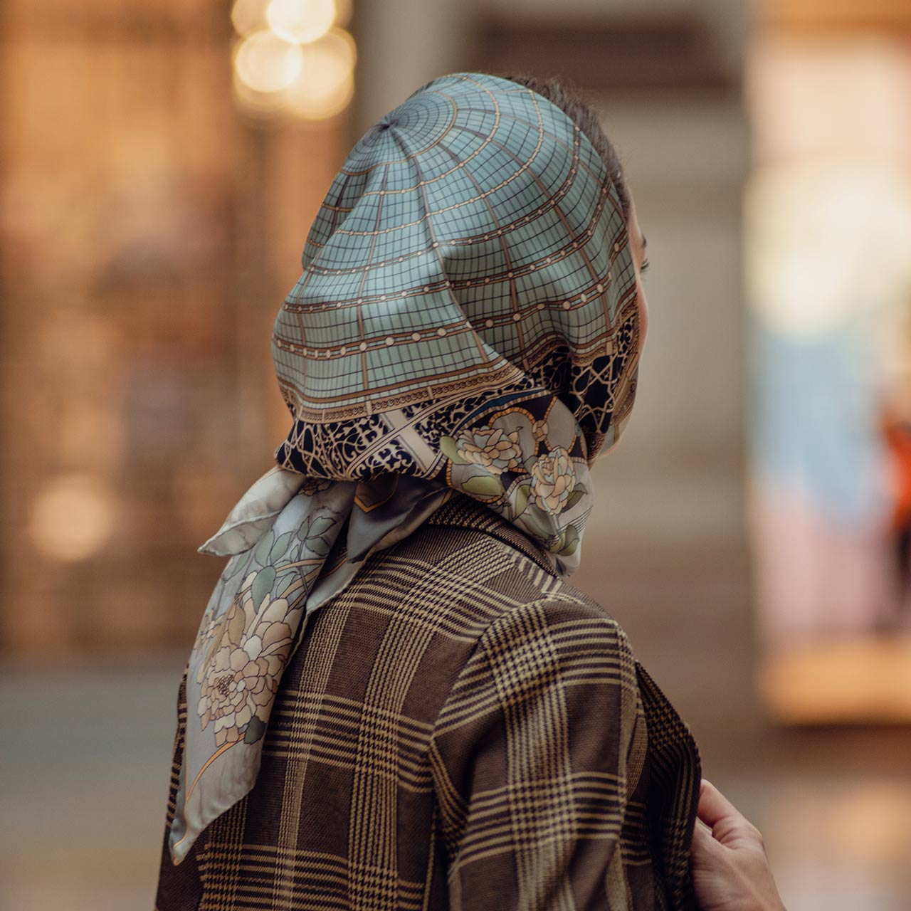 woman wearing a blue, black and gold silk scarf on her head
