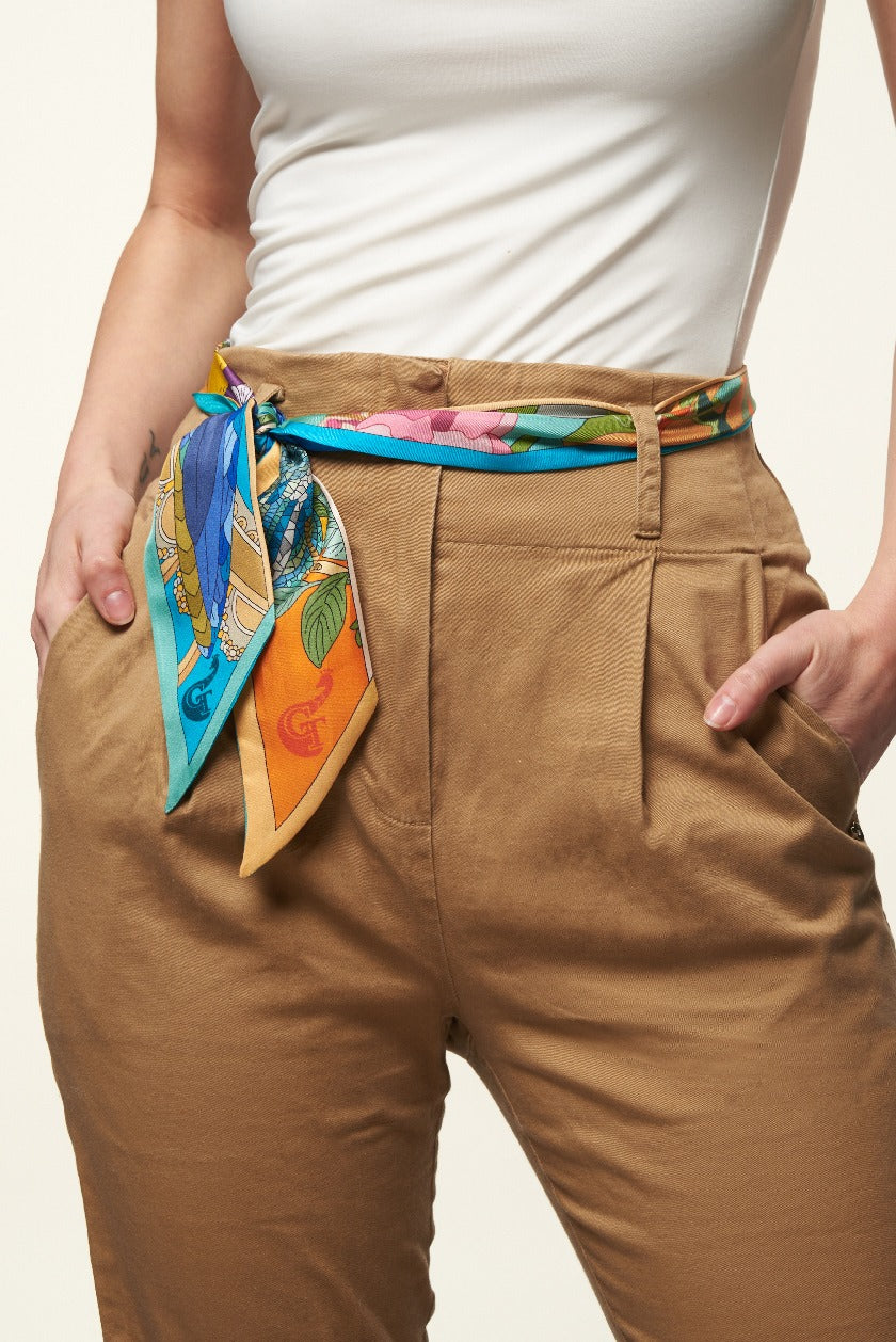 blue and orange silk twilly used as belt by girl with white t-shirt and brown trousers